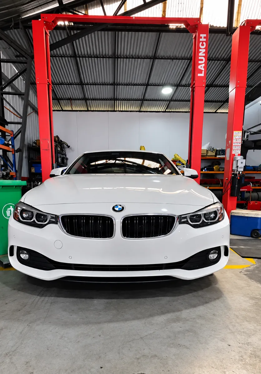 BMW Serie 4 blanco en el elevador del taller BMCARE Motorsport